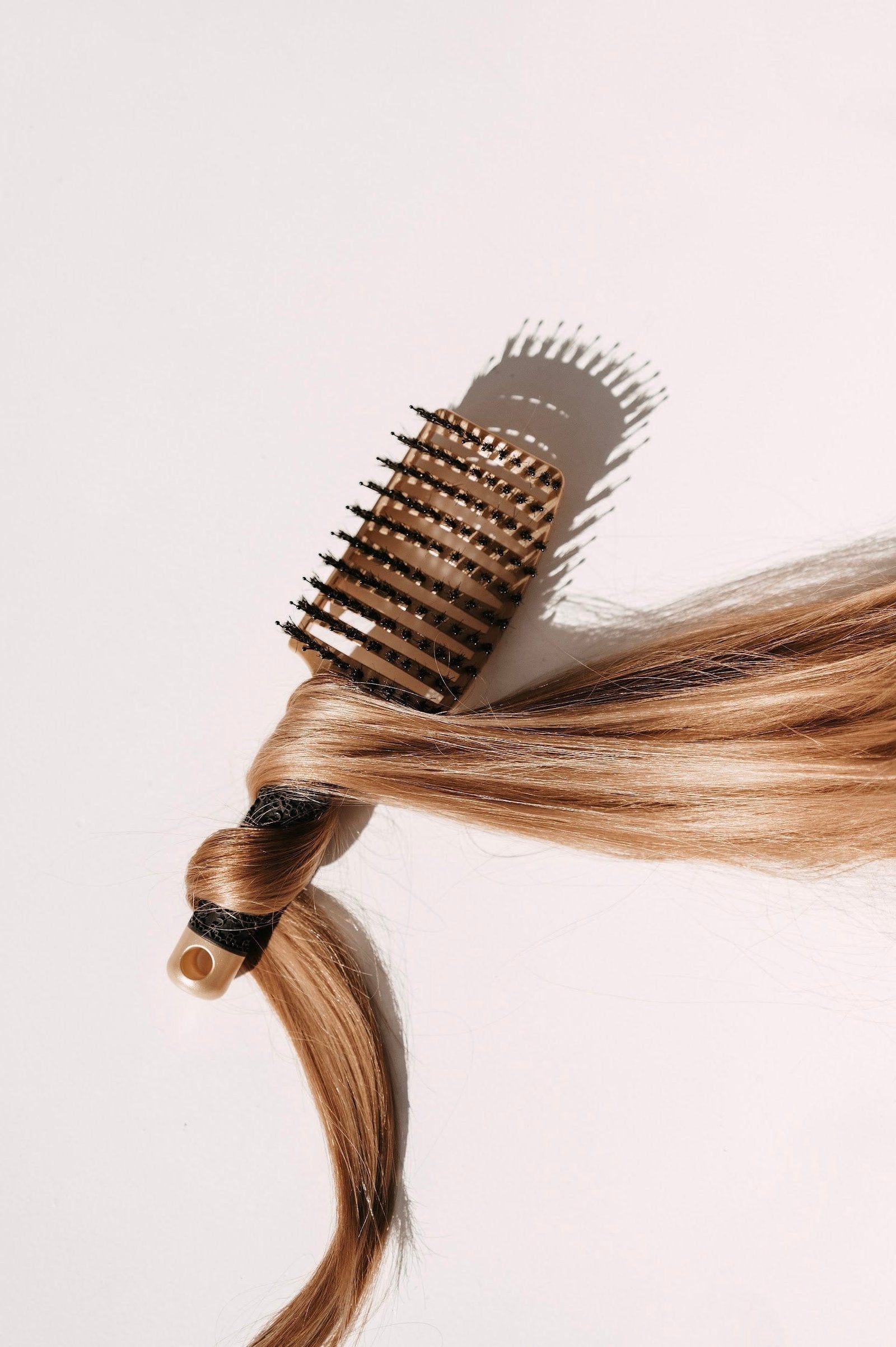 Golden-colored hair comb with a strand of combed hair