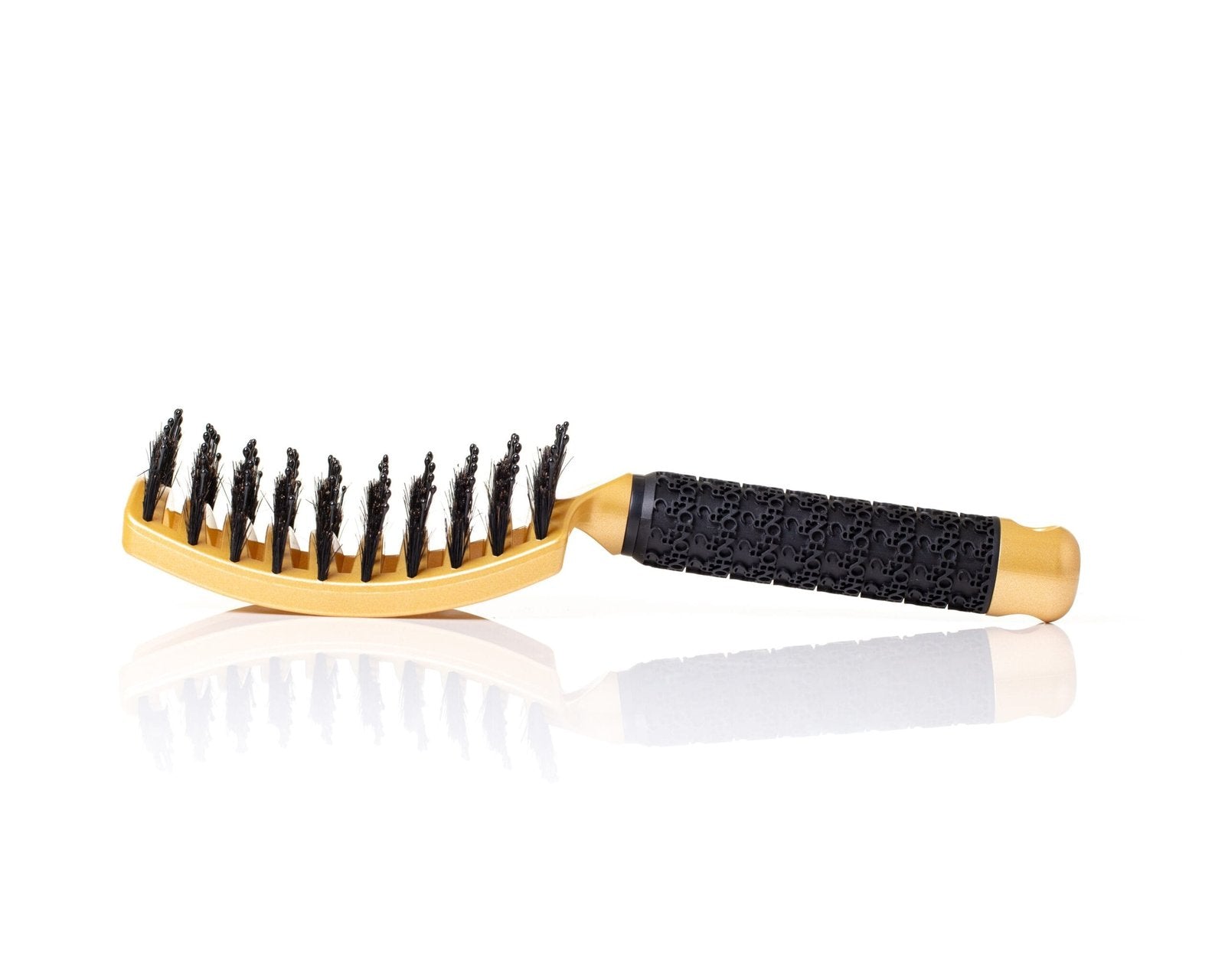 A hair comb in gold color on a mirror surface