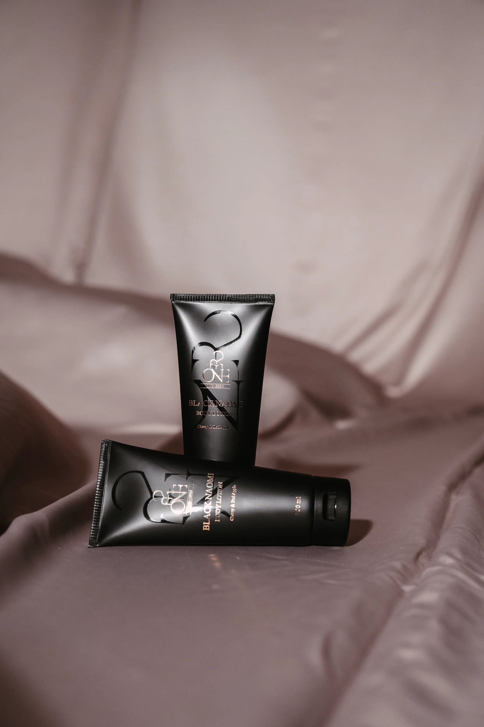 Two tubes of body lotion "Black Naomi" on silk
