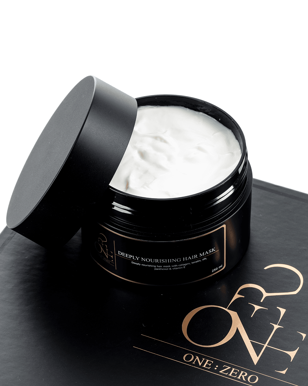 An open jar with a creamy white texture of hair mask
